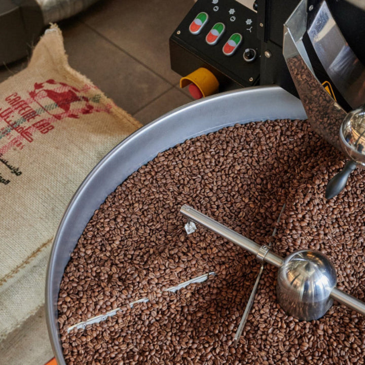 Coffee roastery with roasted coffee beans on it and green beans sack next to it