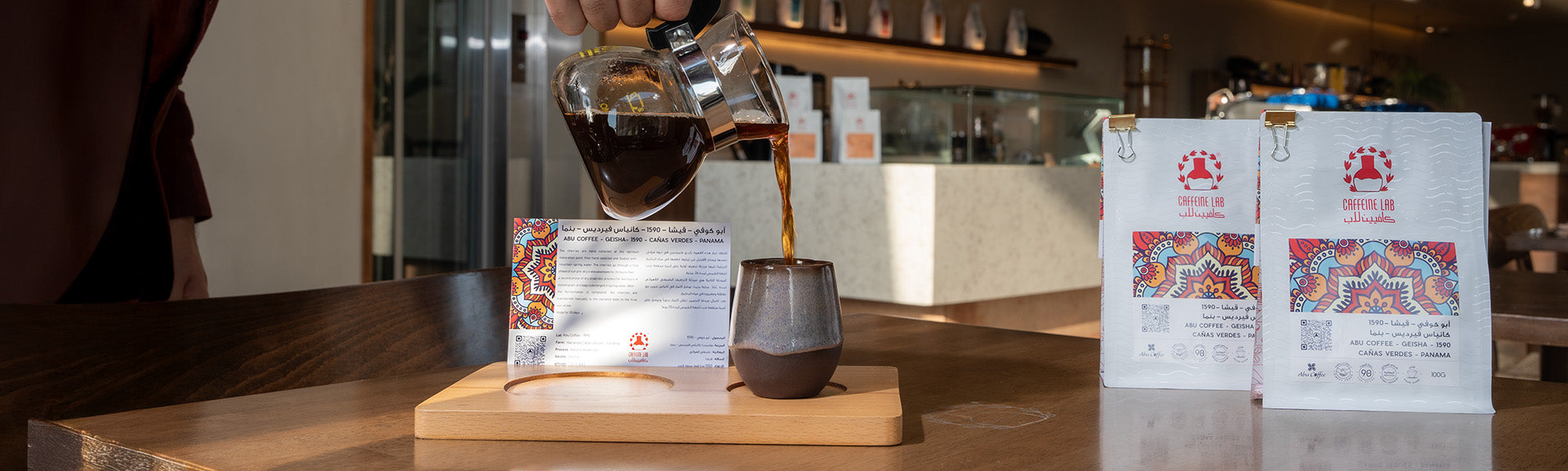 Abu Coffee Geisha 1590 Panama beans bag on the right and brewed or filtered coffee being poured on a coffee mug and the info card is visible
