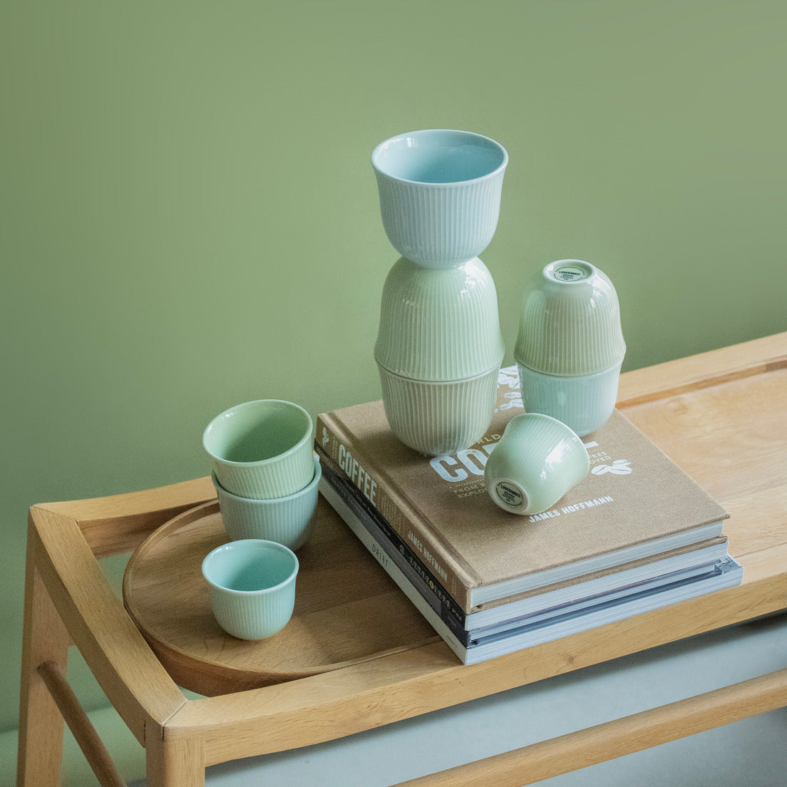 Loveramics Brewers Embossed Tasting Cups in green and blue color. placed above each other on a table with some coffee books with them