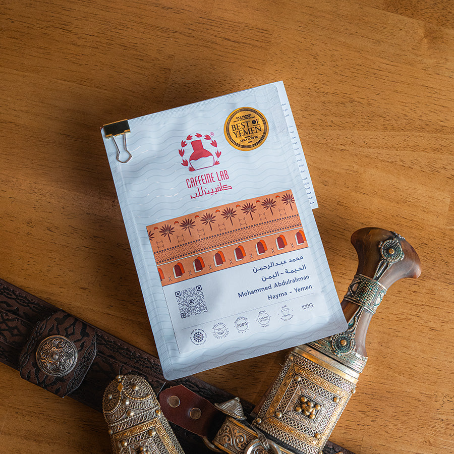 Mobile version of Mohammed Abdulrahman's Hayma Yemen coffee beans and it's the best of Yemen. on a wooden clean table and next to it the traditional Yemeni dagger